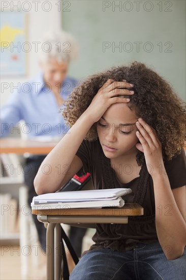 Mixed race student reviewing notes in classroom