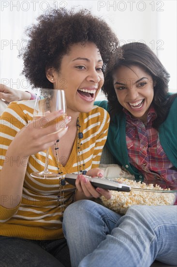 Friends drinking wine and eating popcorn