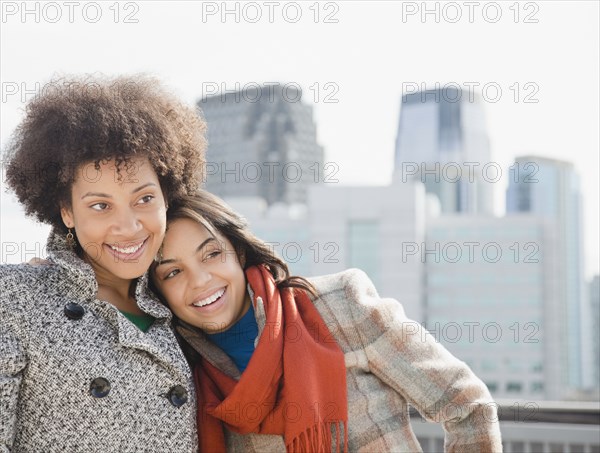 Girlfriends hugging in city