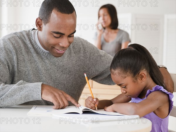 African American father helping daughter with homework