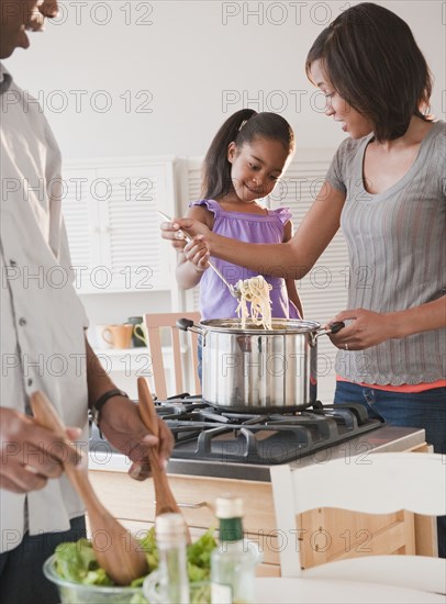 African American mother and daughter preparing dinner