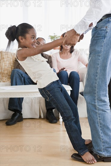 African American father dancing with daughter in living room