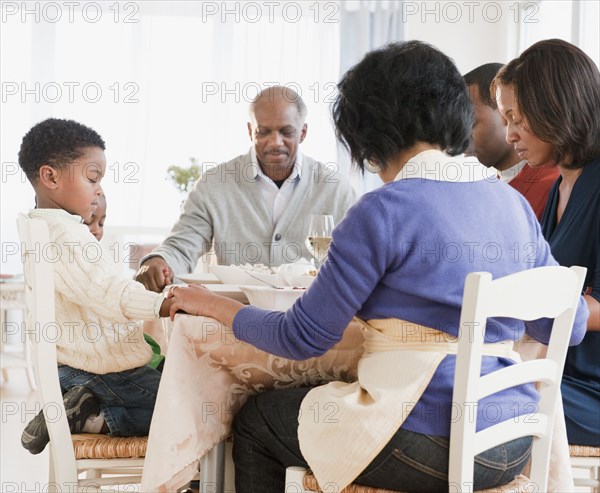 African American family praying before meal