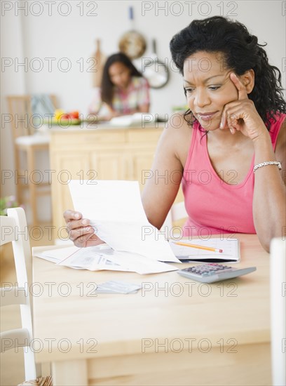 Black mother looking at monthly bills