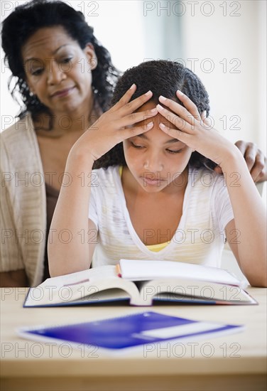 Mother comforting frustrated daughter doing homework