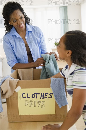 Mother and daughter sorting clothes for clothes drive