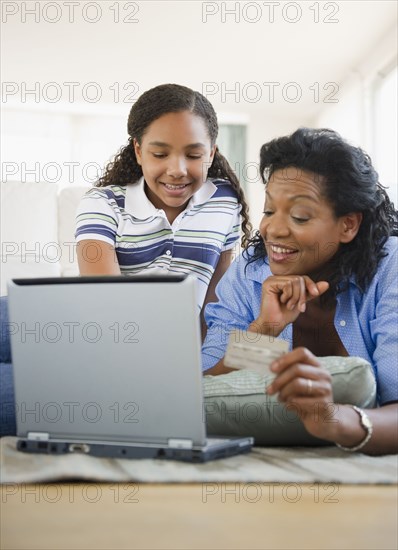 Mother and daughter using credit card online