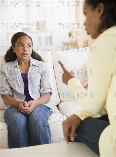 Mother lecturing daughter in living room