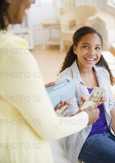 Mother handing money to daughter