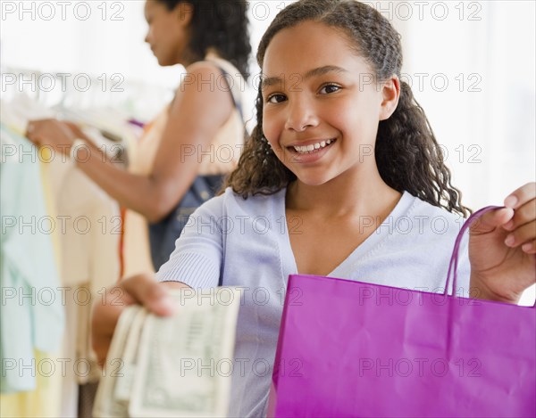 Mixed race girl handing over money in clothing store