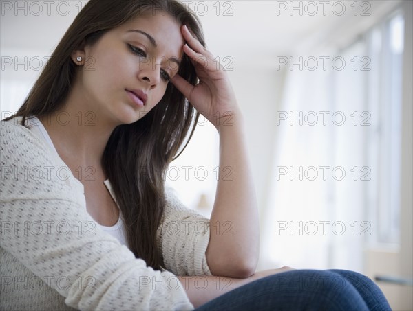 Disappointed Indian woman with head in hands