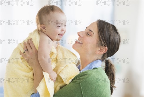 Caucasian mother toweling baby girl with Down Syndrome