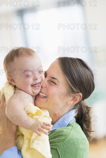 Caucasian mother playing with baby girl with Down Syndrome