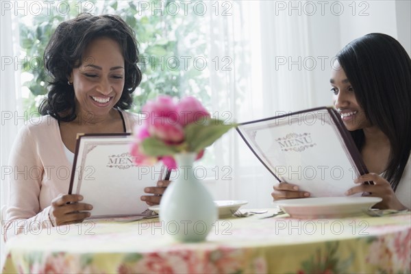Mother and daughter reading menus in restaurant
