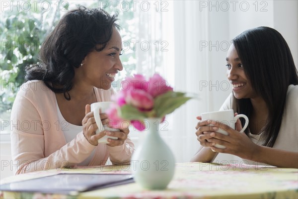Mother and daughter drinking coffee in restaurant