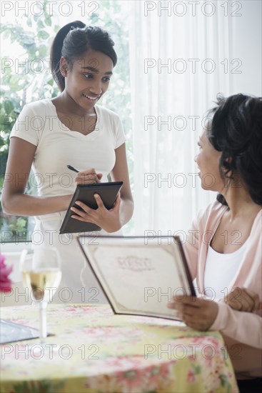 Woman holding menu ordering in restaurant