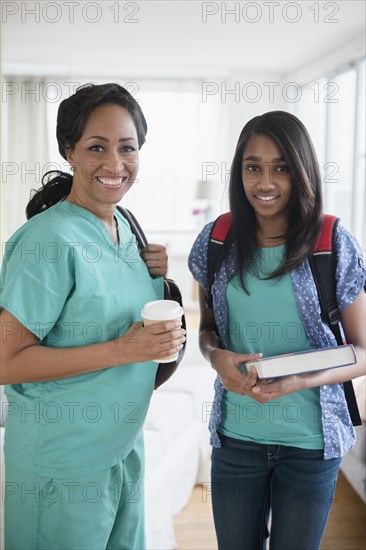 Smiling nurse and daughter leaving house in morning