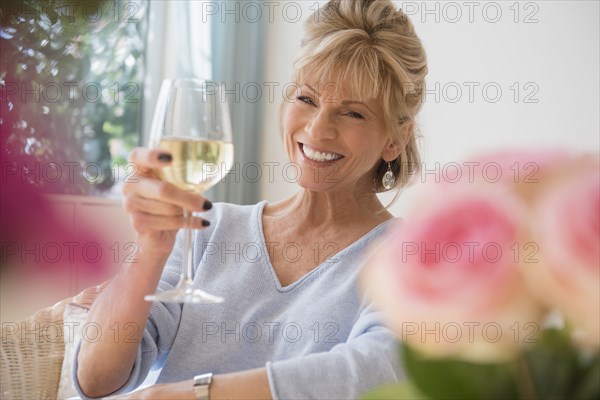 Older Caucasian woman drinking white wine