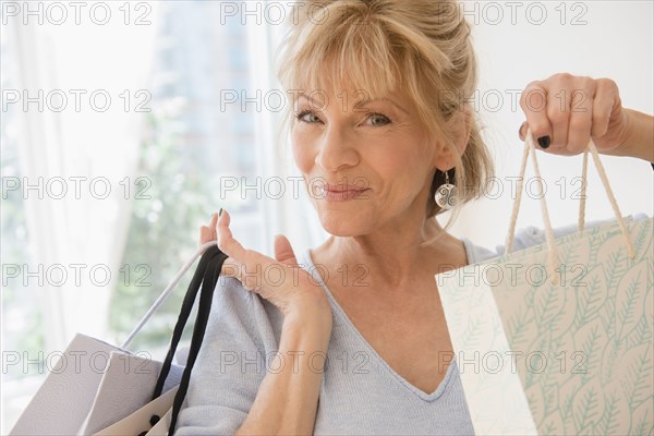 Older Caucasian woman showing shopping bags