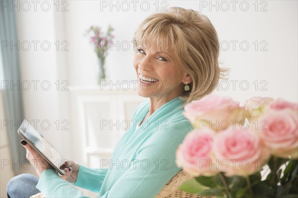 Older Caucasian woman reading digital tablet