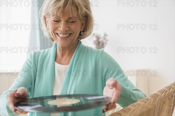 Older Caucasian woman holding vinyl record