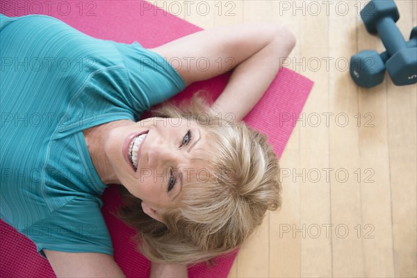 Older Caucasian woman relaxing on exercise mat