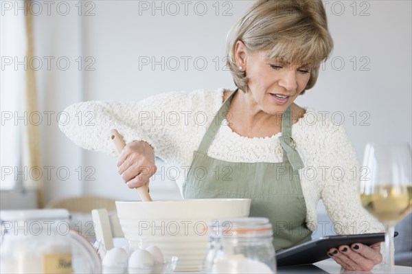 Older Caucasian woman reading recipe on digital tablet