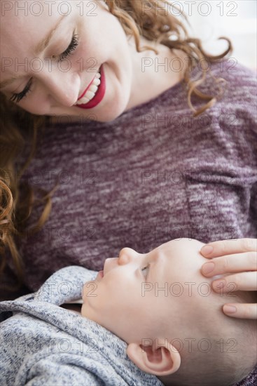 Caucasian woman holding baby son in lap
