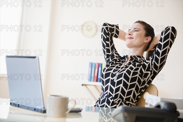 Satisfied Caucasian businesswoman relaxing in office