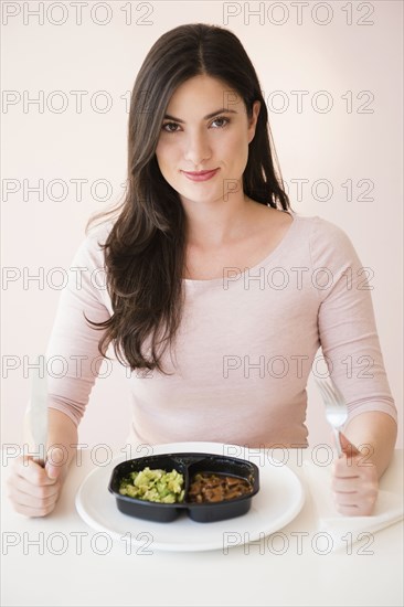 Caucasian woman preparing to eat TV dinner