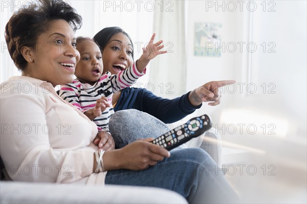 Black multi-generation family watching exciting television