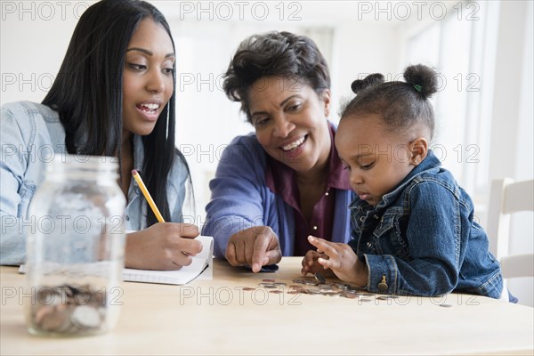 Black multi-generation family counting coins
