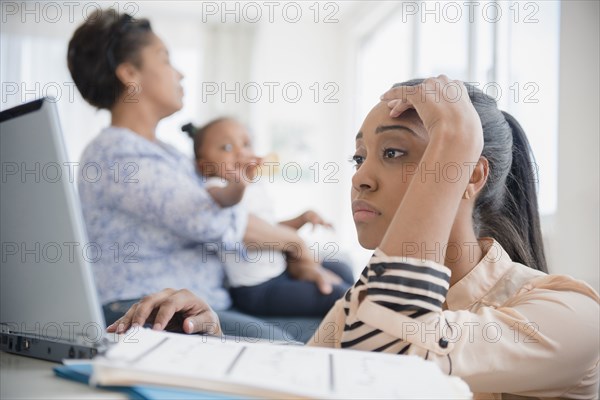 Stressed Black woman paying bills using laptop