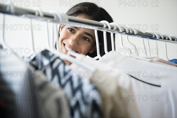 Indian woman smiling near clothing rack