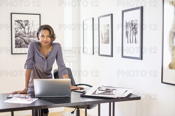 Black woman using laptop in art gallery office