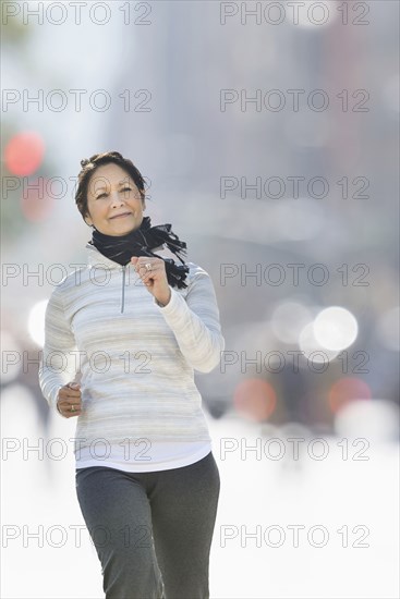 Hispanic woman running in city