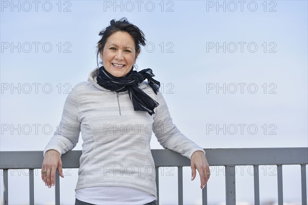 Hispanic woman leaning on railing