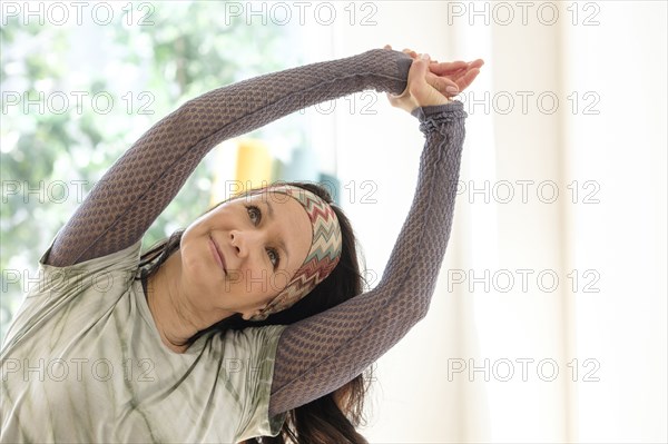 Hispanic woman stretching arms