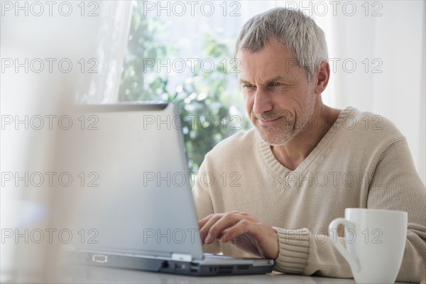 Older Caucasian man using laptop