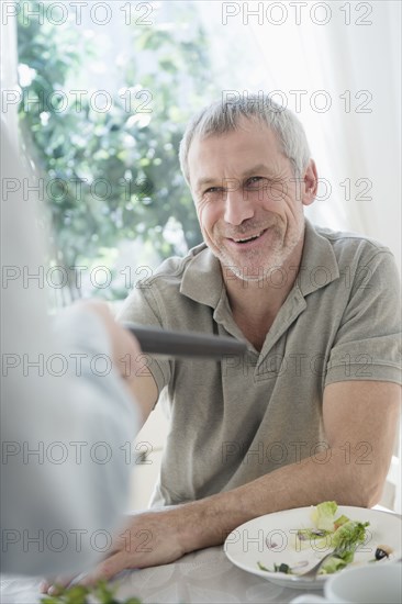 Older Caucasian man  paying bill in restaurant