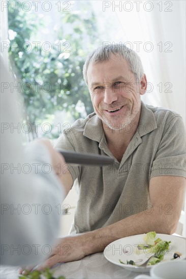 Older Caucasian man paying bill in restaurant