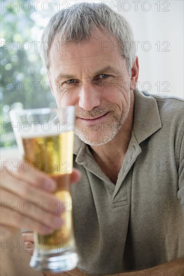 Older Caucasian man toasting with beer glass