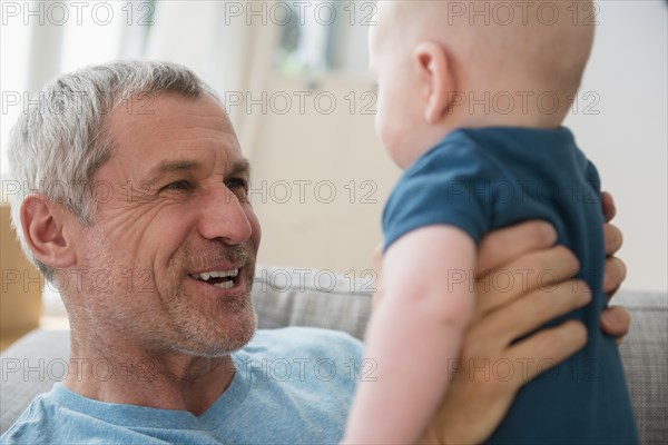 Caucasian grandfather holding grandson face to face