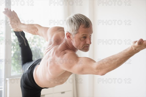 Older Caucasian man doing yoga