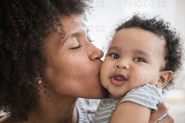 Mother kissing baby son on cheek