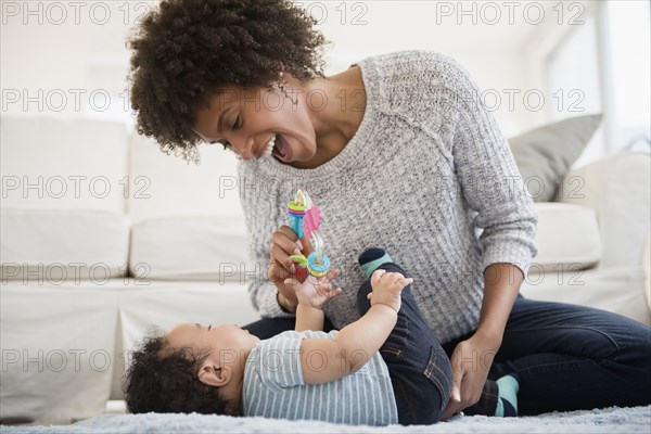 Mother playing with baby son on floor