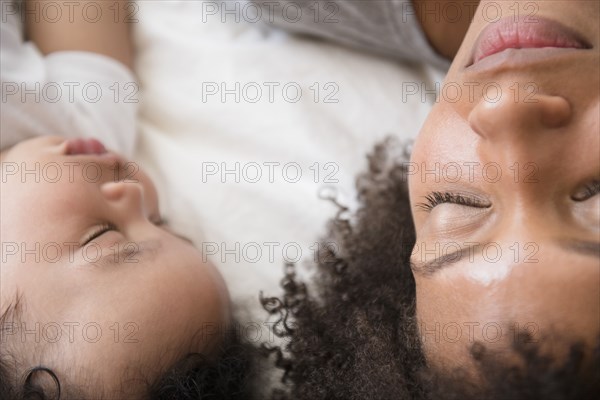 Mother and baby son sleeping on bed