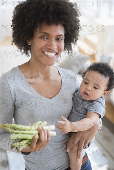 Mother holding asparagus and baby son