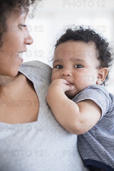 Mother holding teething baby son
