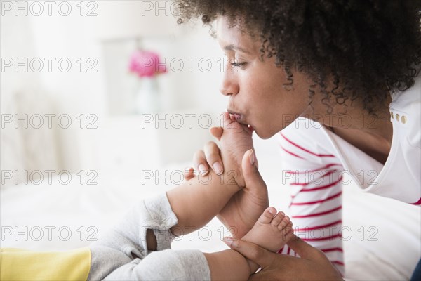 Mother kissing foot of baby son